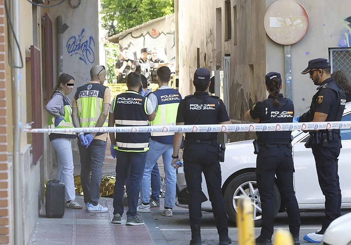 Agentes del Cuerpo Nacional de Policía junto al cadáver del hombre en el barrio de Santiago El Mayor.