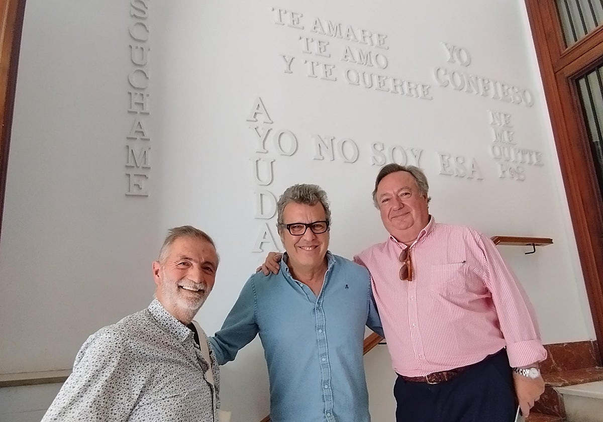 Alfonso Riera, el artista y primo de Mari Trini Alfonso Pasqual del Riquelme Herrero (Akiko) y Gonzalo Pérez-Miravete Mille, en el rellano del edificio donde nació Mari Trini, decorado con los títulos de sus canciones.