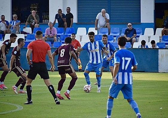 Yasser busca el pase a un compañero rodeado de jugadores del Orihuela, ayer, en El Rubial.