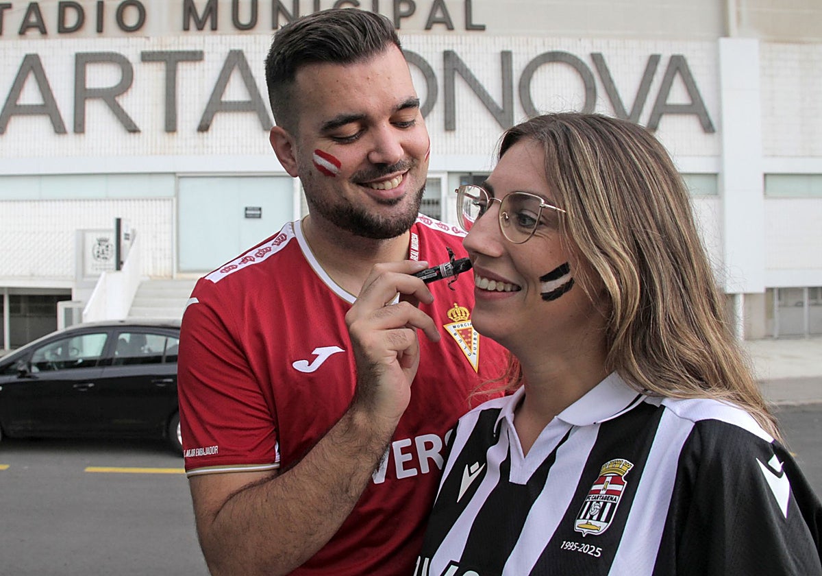 Antonio Gil, murcianista, pinta los colores del Efesé en el rostro de su pareja Pepa Acosta, aficionada albinegra.