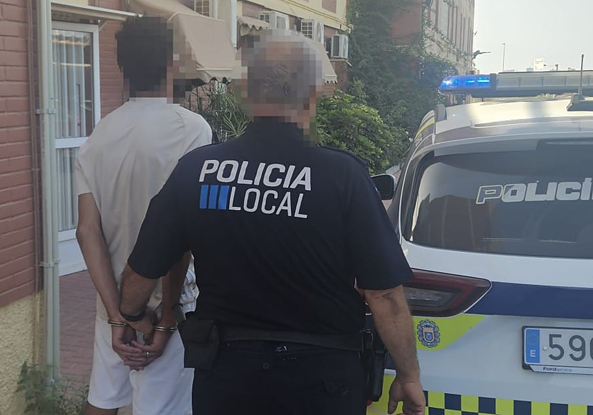 Un policía local de San javier traslada al detenido.