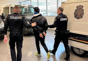 Dos policías trasladan a un detenido.
