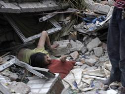 Una mujer trata de escapar de entre los escombros de un edificio derrumbado en Dujiangyan, en la provincia de Sichuan. /REUTERS