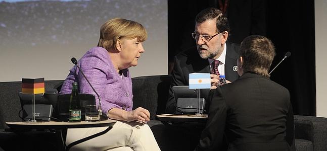 Mariano Rajoy (d), habla con Angela Merkel en Santiago de Chile. / Efe | Atlas
