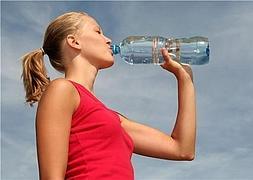 Una mujer bebe agua tras una intensa sesión de ejercicio. / MujerHoy.com