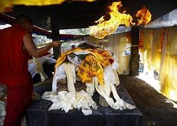 Un monje budista nepalí se prepara para incinerar el cuerpo de uno de los Sherpas fallecidos. / Efe