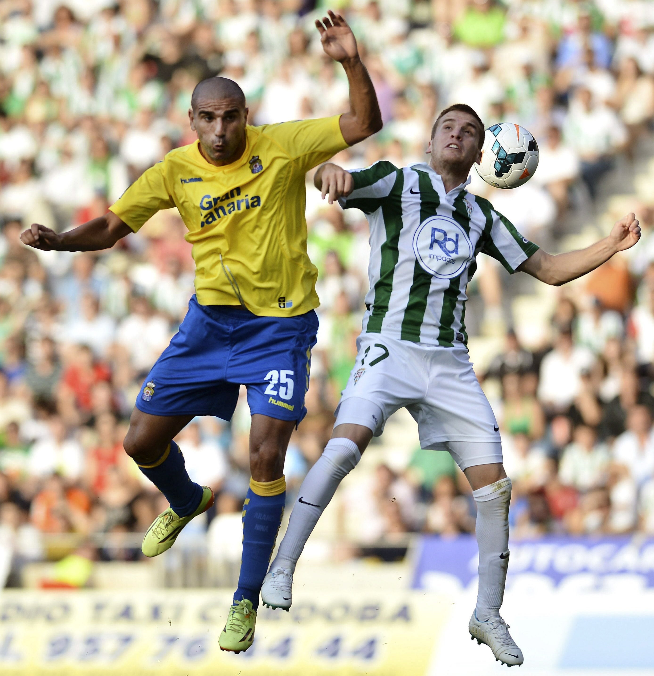 Gunino (d) y Aranda saltan por el balón. 