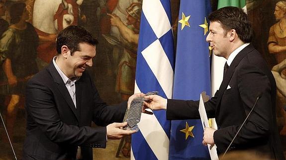 El primer ministro griego, Alexis Tsipras (i), recibe una corbata de manos de su homólogo italiano, Matteo Renzi. 