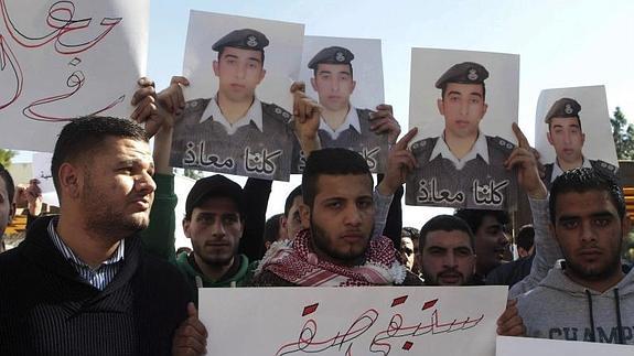 Varios estudiantes muestran fotografías del piloto Muaz Kasasbeh.