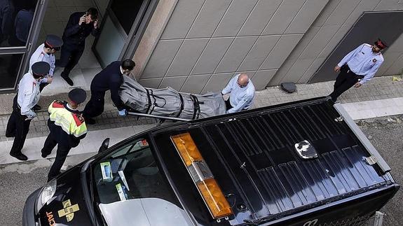 Miembros de los servicios funerarios de Barcelona y del juzgado de guardia retiran el cadáver del profesor.