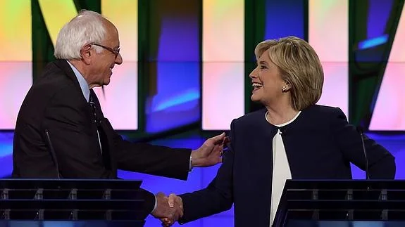 Bernie Sanders estrecha la mano de Hillary Clinton.