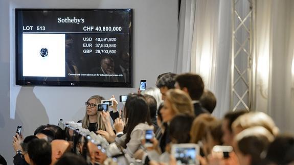 Varias personas inmortalizan el momento cumbre de la subasta.