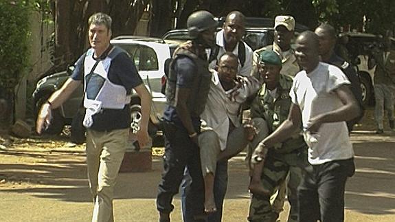 Personal militar de Malí traslada a un hombre herido.