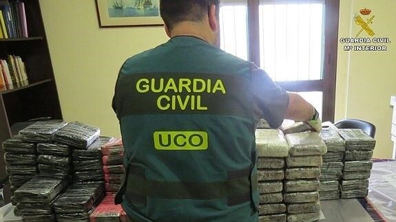 Un agente de la Guardia Civil enumera las placas de cocaína halladas tras el registro de 'Elcano'.