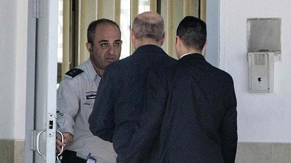 Olmert (c.), en el momento de entrar en la cárcel. 