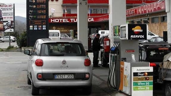 Un coche repostando en una gasolinera. 