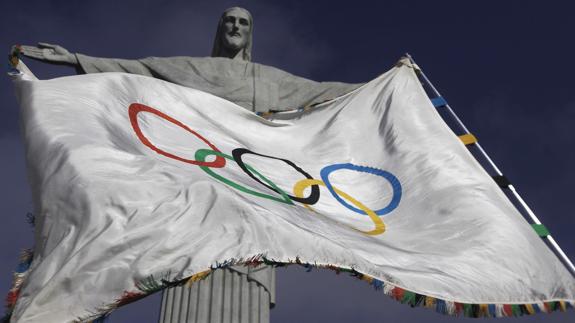 La bandera olímpica ondea junto a la estatua de Cristo Redentor. 