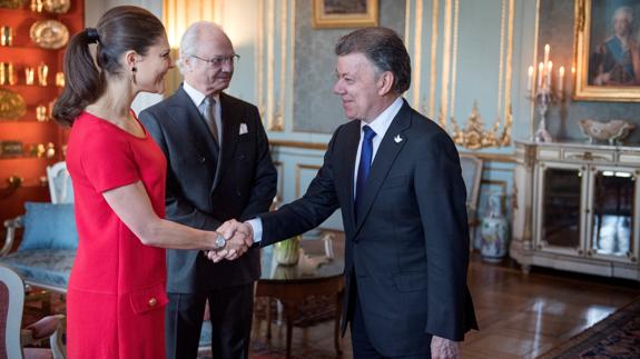 La princesa Victoria de Suecia saluda a Juan Manuel Santos junto al rey Carlos XVI Gustavo de Suecia.