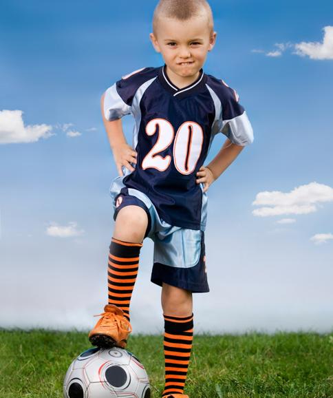 Un niño, listo para jugar al fútbol. 