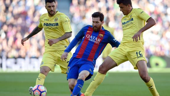 Messi intenta un pase ante dos rivales. 
