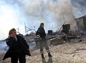 ATAQUE. Dos Policías de Kosovo observan los restos calcinados de un puesto aduanero./ AFP