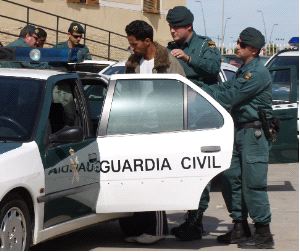 EN LOS NAREJOS. Uno de los presuntos delincuentes detenidos es 		   llevado a un vehículo policial. / A. SALAS