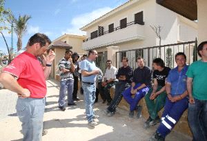 PREOCUPADOS. Trabajadores y subcontratistas de Seop, ante los chalés que construyen. / M. BUESO