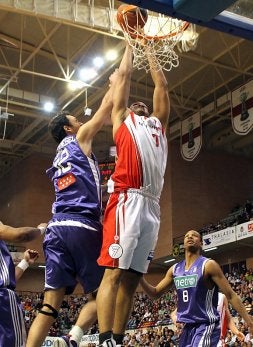 Chris Moss, que logró 12 puntos y 12 rebotes, logra encestar ante el techo merengue, Van den Spiegel. / R. FRANCÉS