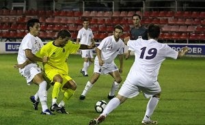 El jugador del Cartagena rodeado de rivales del Caravaca. / E. SOLER
