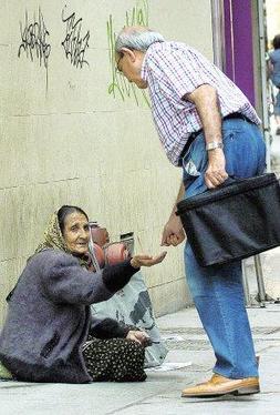 Un hombre dona unas monedas a una indigente en el centro de Murcia. ::                             GUILLERMO CARRIÓN /AGM