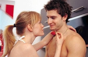 Una pareja se mira entre sonrisas en la intimidad de la cocina. ::                             IMAGELIBRARY