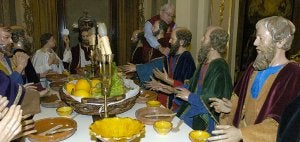 El presidente del Paso Morado, Fulgencio Martínez Pelegrín, coloca las manos de las figuras integrantes de 'La Santa Cena' que realizó Nicolás Salzillo en 1700. ::                             SONIA M. LARIO /                             AGM