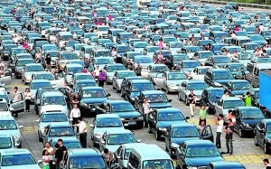 Conductores desesperados esperan junto a sus vehículos.