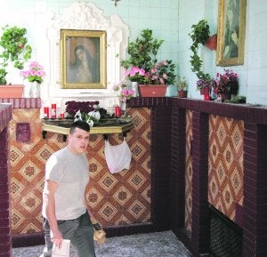 Un hombre pasa ante el popular altar del callejón de la Soledad. ::
J. M. RODRÍGUEZ / AGM