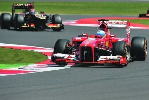 Fernando Alonso, ayer, adelanta y deja atrás al Lotus de Kimi Raikkonen. ::  Ben Stansall / AFP