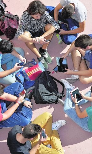 Un grupo de estudiantes de Secundaria utilizan sus móviles y tabletas durante el recreo. ::                             N. GARCÍA / AGM