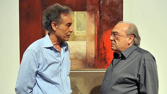 El pintor Pedro Cano y el periodista José García Martínez, ayer, junto a una de las obras del primero, en el Almudí.