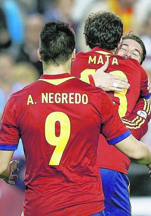 Sergio Ramos abraza a Juan Mata tras un gol de la selección ante Álvaro Negredo. 