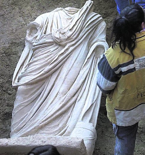 La estatua, cuando fue hallada; y la zona que ocupaba la Curia, en su estado actual de excavación.