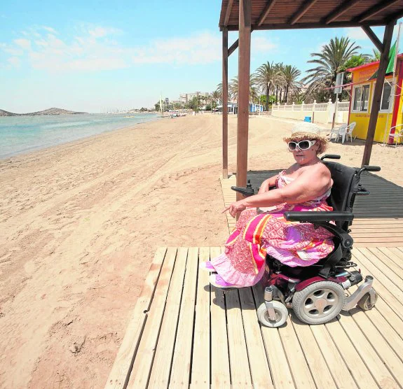 María Valverde, con su silla de ruedas en la pasarela de la playa del Cavanna. :: antonio gil / agm