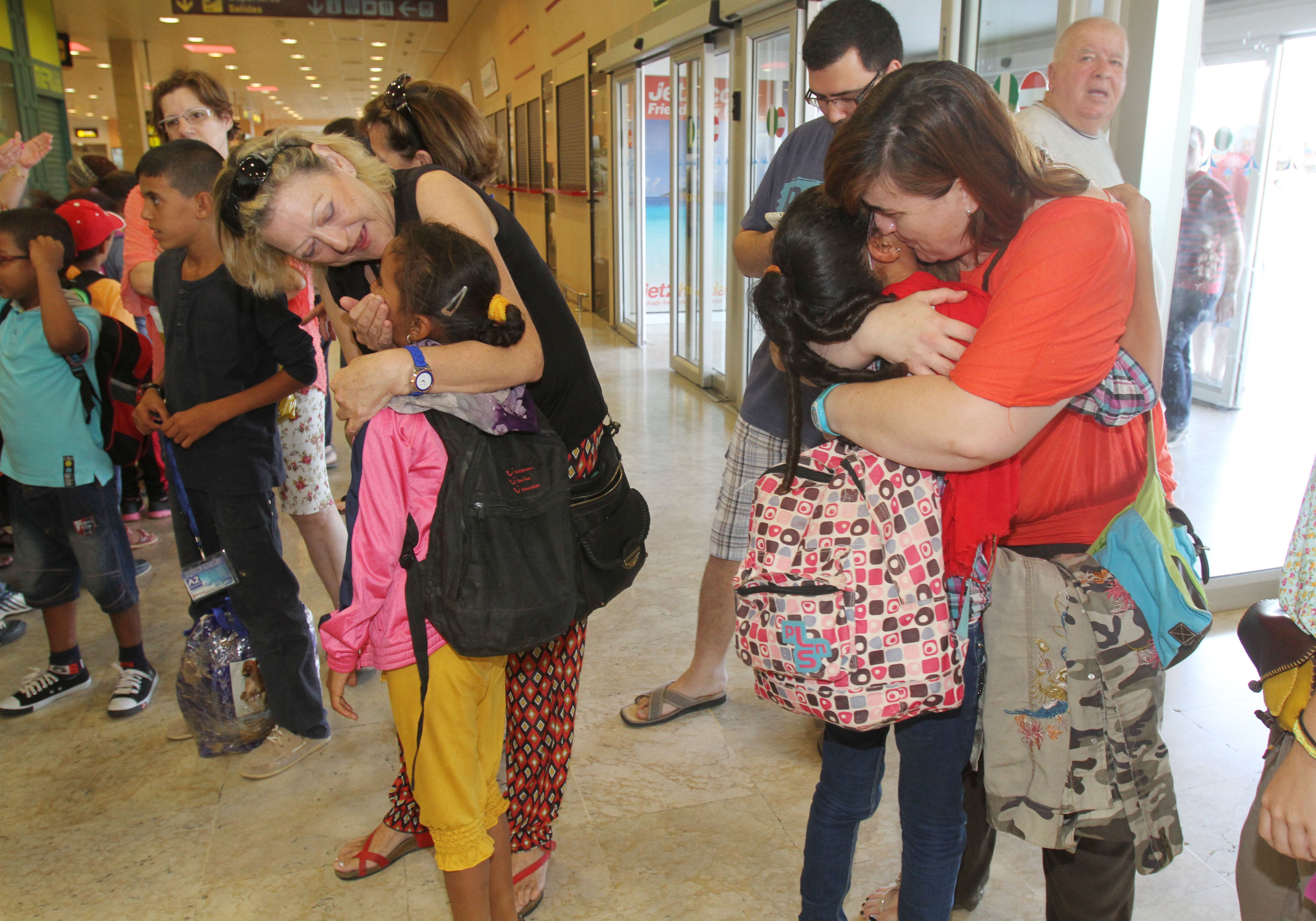 Dos mujeres reciben cariñosamente a dos niñas en el aeropuerto de San Javier