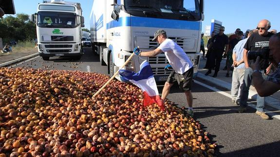 La carga de melocotones, esparcida por la carretera.