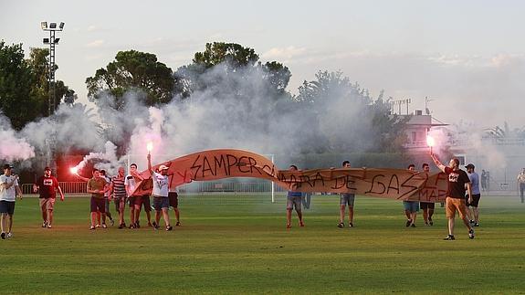 Aficionados del Real Murcia saltan al césped del complejo Miguel Indurain con bengalas y una pancarta contra Samper y Tebas. 