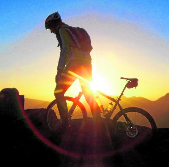 Un ciclista de montaña culmina su trayecto de horas al amanecer en las cumbres de Sierra Nevada. ramón ángel serrano
