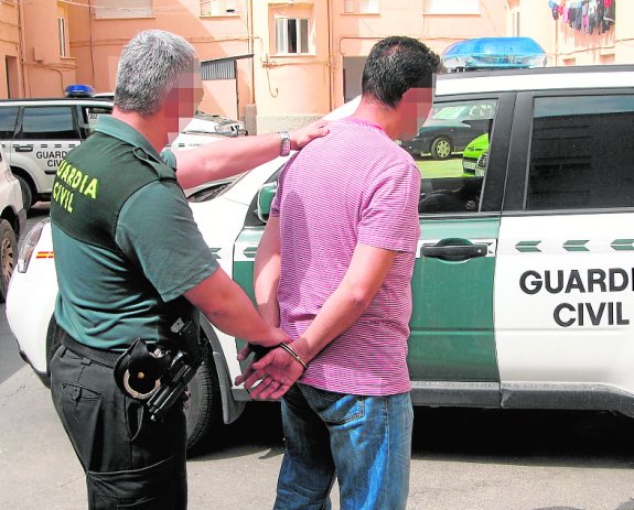 Un guardia traslada a uno de los detenidos en Cartagena. 