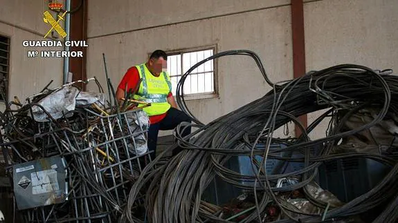 Agente desmantelando el cableado sustraído. 