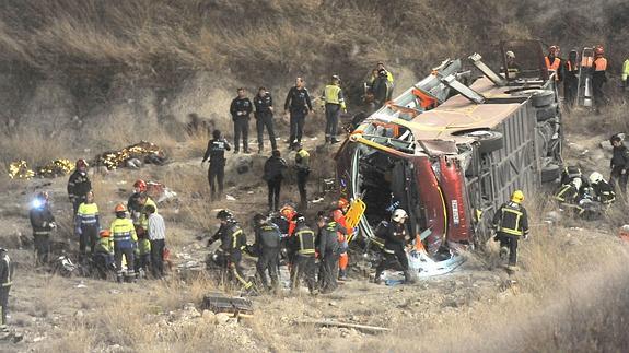 Bomberos y personal sanitario ayudan a los heridos en el lugar del accidente. 