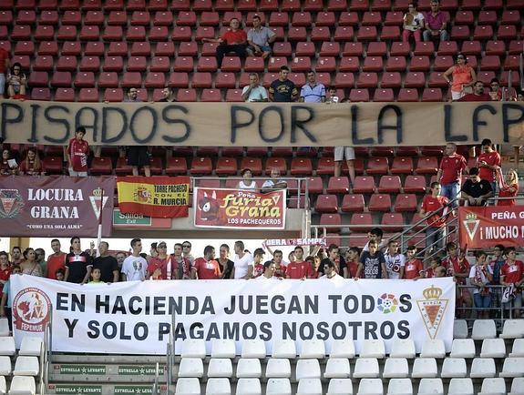 Aficionados del Murcia muestran su descontento con una pancarta. 