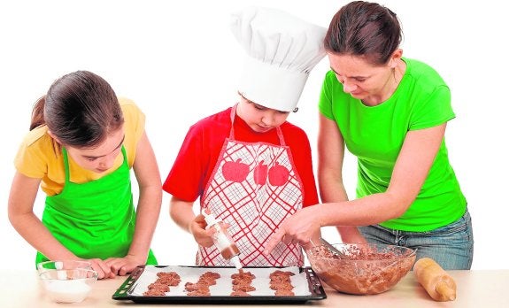 Unos niños elaboran galletas.