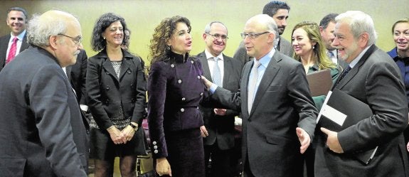 Cristóbal Montoro conversa con diversos consejeros a su llegada a la reunión del Consejo de Política Fiscal y Financiera, ayer en Madrid. 